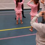 Lapset tanssimassa liikuntasalissa. 