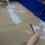 Lapset maalaavat pahvia. 
