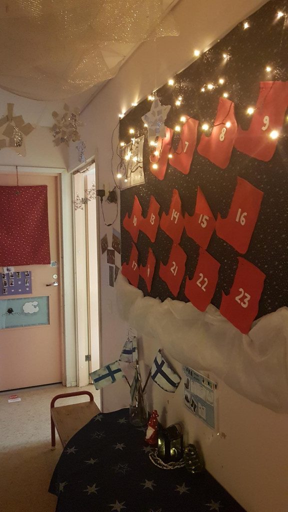 Kuvassa numeroidut joulusukat, jotka muodostavat joulukalenterimme. Kuvassa näkyy myös lasten askartelemia Suomen lippuja Itsenäisyyspäivän kunniaksi.