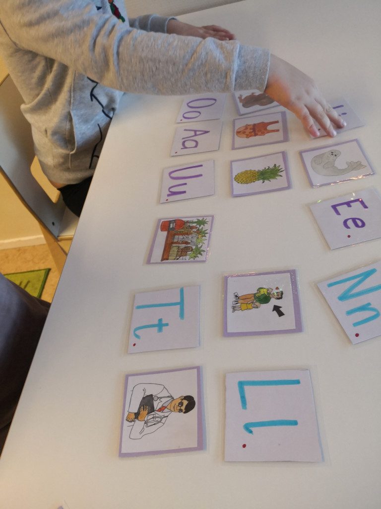 Lapsi tutkii alkuäännemuistipelin kortteja.