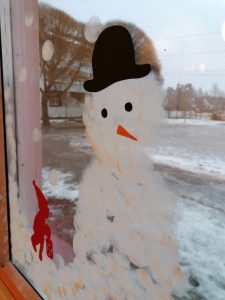 Ikkunaan maalattu lumiukko. 