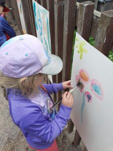 Tyttö maalaa vesiväreillä.