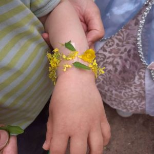 Lapsella kukkakoru kädessä.