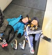 Kaksi lasta makaa väsyneenä lattialla.