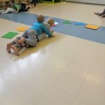 Jumppasalissa neljän lapsen pitää liikkua pareittain niin että toisen vatsa on kiinni lattiassa ja toisen vatsa parinsa selässä.