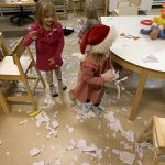 Kaksi lasta valmistautuu lumen eli paperisilpun heittämiseen