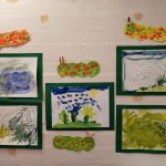 lasten vesivärimaalauksia ja toukka-askarteluja seinällä