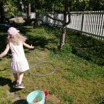 lapsi heittää vesi-ilmapalloa renkaan läpi tarkkuusheittona