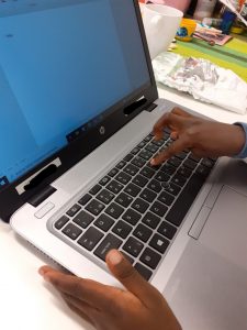 lapsi kirjoittaa tietokoneella.