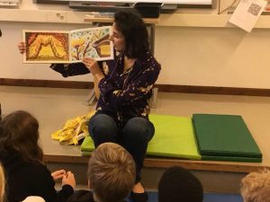 Taiteilija lukee kirjaansa oppilaille