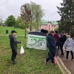 Ryhmä lapsia on kerännyt roskia Puolalan puistosta ja kuvassa he laittavat roskapussit isoon roskasäiliöön.