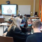 Kuva luokasta: etualalla oppilailta, taustalla näkyy Smartboard ja opettaja