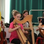 Oppilaita soittamassa kevätkonsertissa harppua, viulua, kitaraa ja rumpuja.