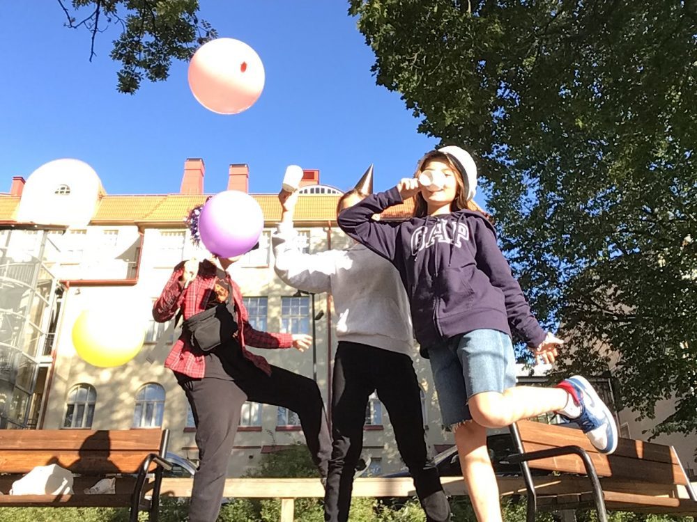 Klme oppilasta esittämässä vapun juhlintaa ilmapallojen kera
