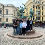 Koeskellä näkyy Kolmen sepän-patsas Helsingissä. Sen ympärillä on oppilaita.