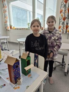 Kaksi kerholaista valmiiden maitotölkkilinnunpönttöjen kanssa.