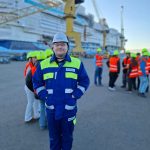 Kypäräpäinen ja turvaliivinen telakan työntekijä, joka vastasi kiertueesta.