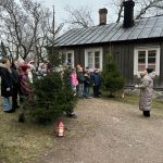 Oppilaita ulkovaatteissaan Käsityöläismuseon mäellä. Taustalla punainen valkoikkunanpielinen asuinrakennus 1800-luvulta.