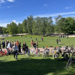 Oppilaita ja polkupyöriä isolla viheriöllä.
