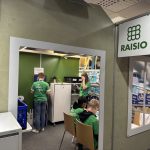 Yrityskylässä Raision (elintarvikeyritys) työpiste: oppilaita työskentelemässä .